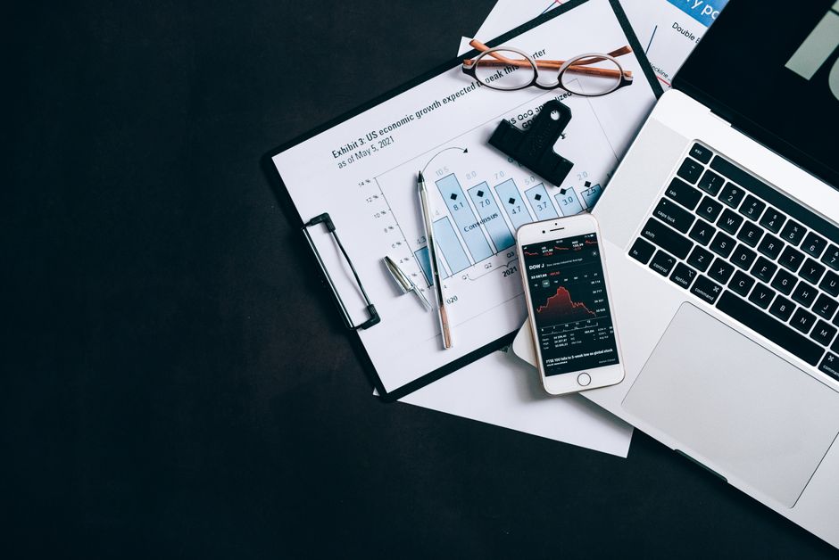 Strong corporate governance stocks — High angle view of an office desk with laptop, clipboard, and smartphone displaying